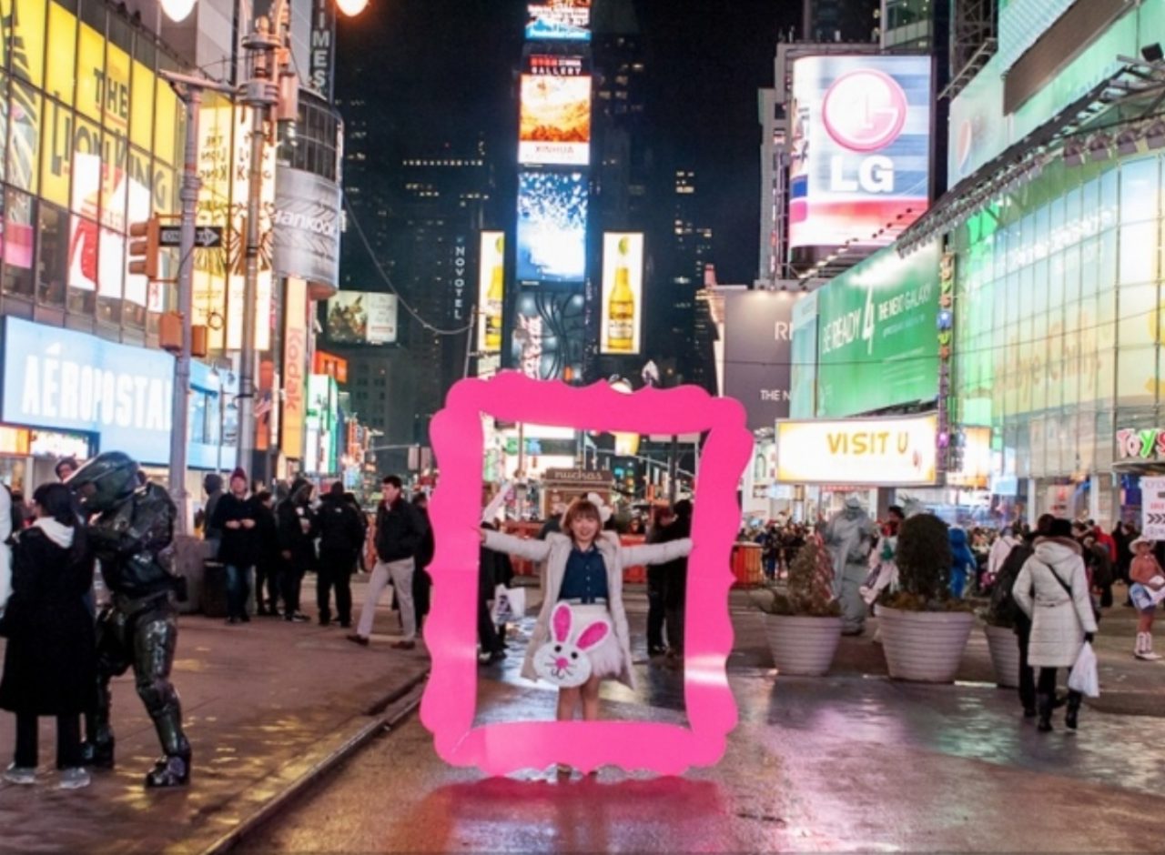 画像: NYで。巨大なピンクフレームを広げる著者。