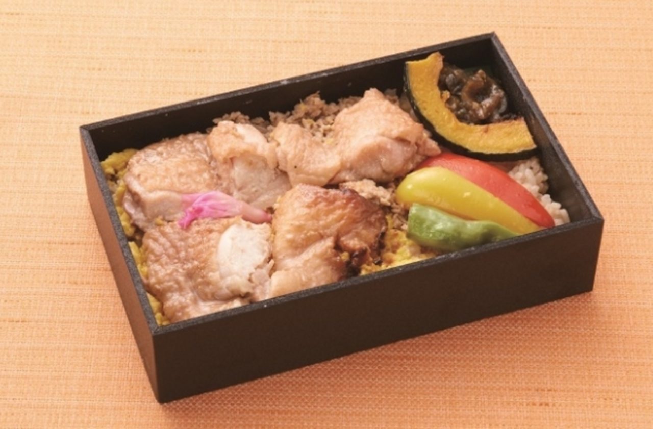 画像: ■岩手の恵 菜・彩・鶏 醤油麹焼弁当　（905円） 鶏肉の旨味を心ゆくまでお楽しみいただけるどら弁当。 メイン食材となる鶏肉は、岩手県が誇る銘柄鶏の『菜・彩・鶏』を醤油麹に漬け込んでから、さらに裏面に醤油麹を塗り込み、こんがりと焼き上げました。主に植物性の飼料を使って生育されているので、鶏肉特有のクセや臭みがなく、冷めても柔らかいので、鶏肉が苦手な方でも美味しく召し上がっていただけます。 『菜・彩・鶏のそぼろ煮』は、ひき肉を適度な甘辛味の炒り煮に仕上げています。 『南蛮味噌漬け』は、岩手県産の南蛮を使用して、ピリッとした辛さのなかにも旨味を感じていただける、後を引く味わいです。 また、ご飯には鶏肉のダシと焼き鳥のタレで炊き上げた、味ご飯としており、鶏肉の旨味を心ゆくまでお楽しみいただけるどら弁当となっております。