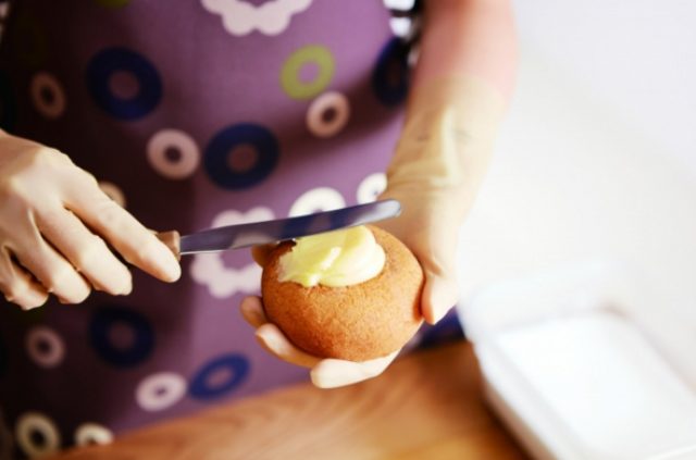 画像: 1.ふんわりとした揚げシュー生地に、本商品専用に新開発したカスタードクリームを塗ります。