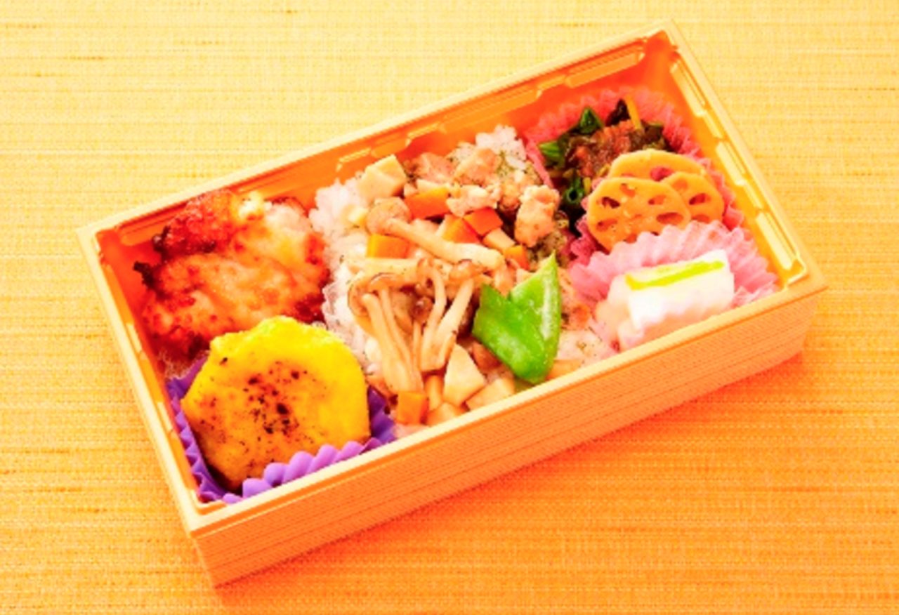 画像: ■健親彩弁当 (810円) 女子大生が両親へ「ずっと健康で」と願いをこめて彩りあざやかに作ったお弁当。 埼玉県の跡見女子大学の学生3名と一緒に考え、作りました。テーマは「健康を意識して栄養素の豊富な食材を使った、親に食べて欲しいお弁当」。日本三大銘茶と言われる埼玉県産の狭山茶を使用した爽やかな香りのお茶ごはんの上には懐かしい味わいの煮物をのせ、味が淡泊になりすぎないよう工夫しています。また、おかずには、多くの方から好まれる唐揚げをヘルシーにアレンジした鶏の揚げ焼きを入れ、食べごたえと味わい、健康面を兼ね備えた主菜にしました。 他にはれんこんのきんぴらやほうれん草の梅肉ソースがけ、埼玉県産の柚子を使った漬物など、お弁当全体のバランスを考えた副菜となっています。 デザートにはかぼちゃのスイートポテトを入れ、素材の味をいかしたやさしい甘さで満足感を出しました。 食感、味、ボリューム、そして健康志向にこだわった、飽きのこないお弁当となっています。