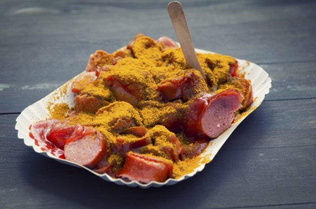 画像: ドイツでとても人気のあるファストフード、カレーヴルストは、スチームしてから焼いたポークソーセージにカレー粉とケチャップで味付けしたものです。この伝統的な料理の起源は、ドイツにいたイギリス軍人からカレー粉とケチャップをもらった地元の調理師ヘルタ・ホイヴァーが独自のソースを考案したことから始まります。ドイツ国内で最初のカレーヴルストのレストラン”カレードイツランド”では、この伝統的な料理に独創的なアイデアが盛り込まれ、サテソースで味付けされたカレーヴルストが味わえます。