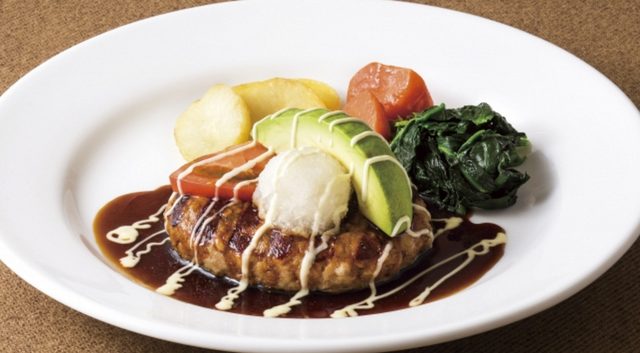 画像: 照焼ソースとわさびマヨのアボカドハンバーグ 878円(税込948円) 春の登場を待たれるほどの人気メニュー「アボカドハンバーグ」。今年は和風の仕立てで登場です。ジューシーな合挽きハンバーグにフレッシュのアボカド、トマト、大根おろしを盛りつけ、醤油の風味をいかしたコク深い照焼ソースで仕上げました。ピリッとしたわさびマヨをアクセントにしたり、大根おろしを合わせてさっぱりとお召し上がりいただいたりと、最後まで味わいの変化をお楽しみいただける一皿です。