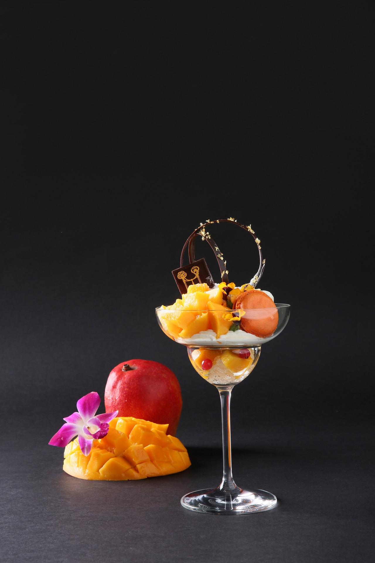 画像: 【完熟アップルマンゴーのフルーツパフェ】 1,300円(消費税込・サービス料別途12%) 完熟アップルマンゴーをふんだんに使用したフレッシュフルーツパフェ。 アップルマンゴーのソルベ、ココナッツソルベ、トロピカルフルーツのマカロンをシャンパンのジュレと楽しむ、大人の新感覚パフェは常夏のリゾート気分を味わえます。