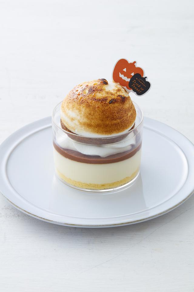 画像: ■商品名:ベリーヌ スモア<ハロウィンバージョン> ■価格:562円(税込) ■販売期間:10月1日(土)~ 10月31日(月) ■商品説明:アメリカやカナダのBBQやキャンプには欠かせない“スモア”※をベリーヌ仕立てにしました。 マシュマロをイメージした焼き色をつけたイタリアンメレンゲ、ほんのり塩味を効かせたビスケット、生クリーム、刻んだカカオ豆を加えたほろ苦いガナッシュクリーム、口どけの軽いホワイトチョコムース、スポンジ生地を重ねました。 ※スモア・・キャンプファイヤーやBBQの火でマシュマロを焼き、チョコレートと一緒にグラハムクラッカーやクッキーではさんだスイーツ。 ※期間限定でジャック・オ・ランタンの飾りが付きます。