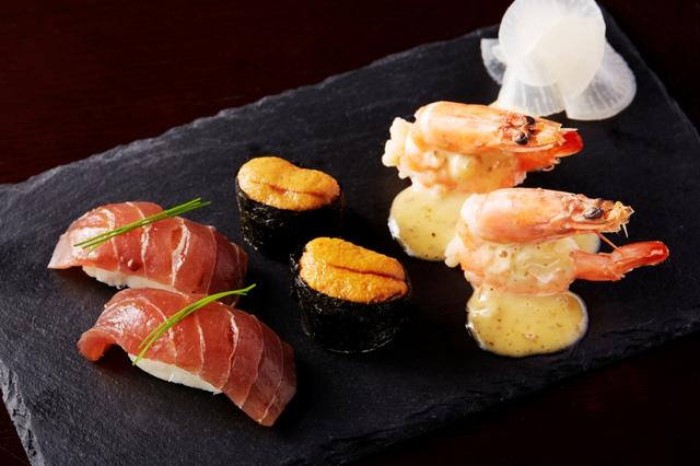 画像: GENIE'S カメレオンSUSHI 一見お寿司に見えるこの料理は、寿司のようなフランス料理です。赤ワインソースを塗ったマグロの下には鱈のブランダードを。ウニ軍艦の中にはホタテのムースとオマール海老を使用したアメリケーヌソースを。ソースベアルネーズをかけたエビの中には押し麦を詰めて寿司に見立てました。最後に桃シロップとレモン汁に漬けたガリを添えています。 ※こちらのみ2名分で1皿