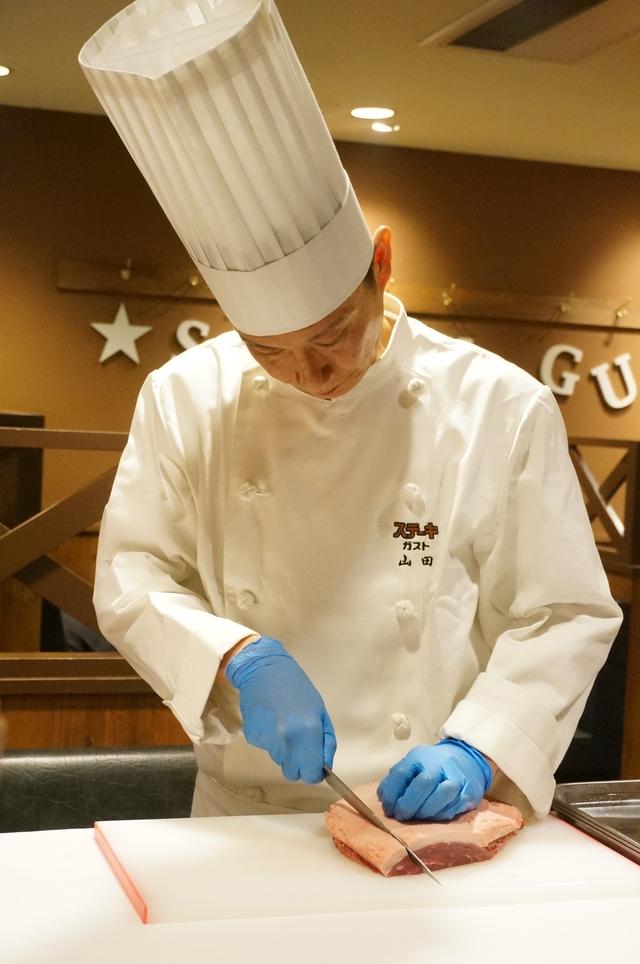 画像: 店舗で塊肉から手切りで一枚ずつ切り出します。 試食会ではシェフによるイチボ塊肉カッティングの実演が行なわれました。