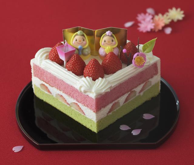 画像: 価 格: Sサイズ(一辺12cm、3~4人分)/¥2,600(税込¥2,808) Mサイズ(一辺13cm、4~5人分)/¥3,100(税込¥3,348) 特 長: 抹茶スポンジと苺風味スポンジの間に苺と生クリームをサンドしました。粒より苺とおだいりさま&おひなさまのかわいい砂糖菓子を飾った扇形の華やかなデコレーションケーキ。雪がとけて大地に草が芽生え、桃の花が咲く。白、緑、ピンクにはそんな意味があります。