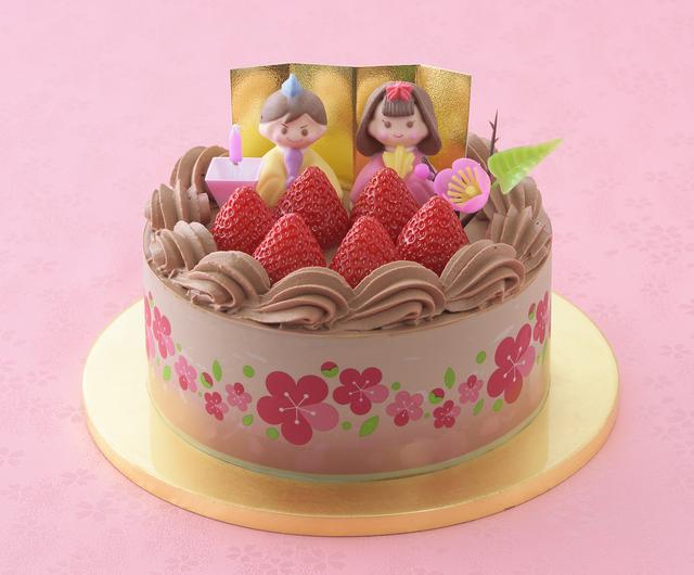 画像: 価 格: 直径15cm、5~6人分/¥2,900(税込¥3,132) 特 長: チョコ生クリームと苺ジャムをココアスポンジでサンド。まろやかチョコ生クリームで仕上げて、おだいりさま&おひなさま、粒より苺を飾りました。苺ジャムの甘酸っぱさがおいしさのアクセント。チョコ好きの方におすすめしたいひなケーキです。