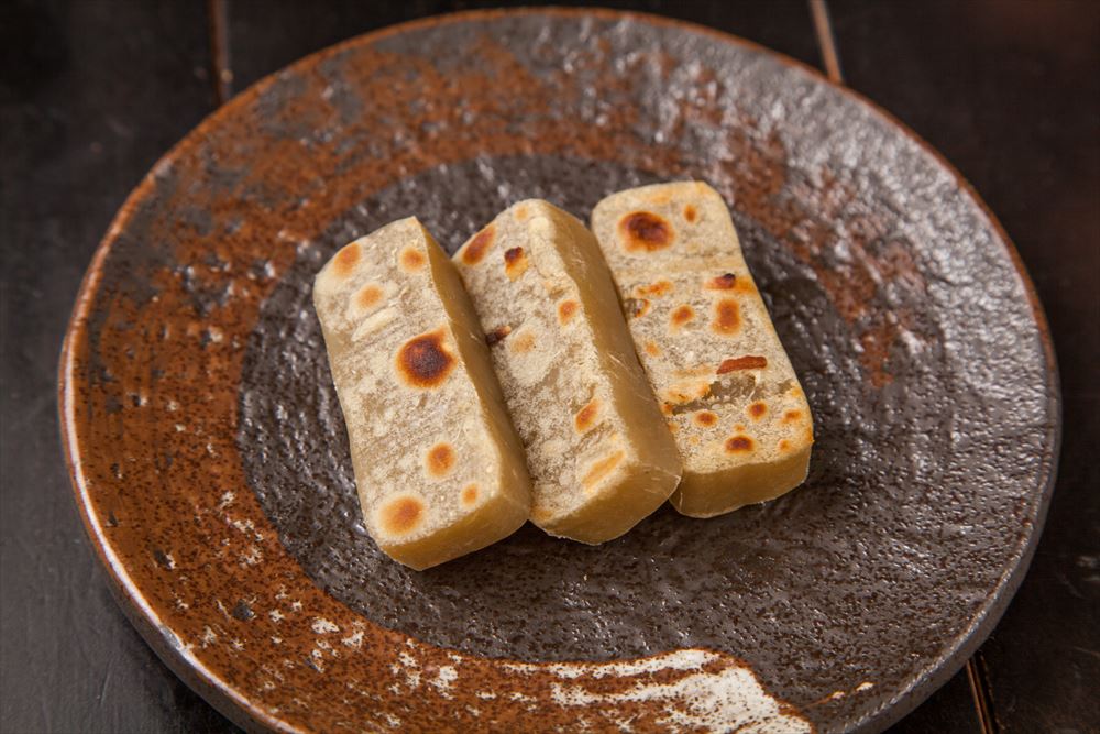 画像: 「五島の名産品」の炉端焼き 軽く炙ると独特の香りが広がり、通好みにはたまらない「塩アゴ」をはじめ、五島の郷土料理を代表する「かんころ餅」も炉端焼きでご用意。また、焼いた長茄子を代表のいとこでもある五島「山本海産物」の鰹節をまぶしてご提供します。 ■五島名物 塩アゴ炙り 880円 ■五島名物 かんころ餅 480円 ■長茄子焼き 鰹節まみれ 880円