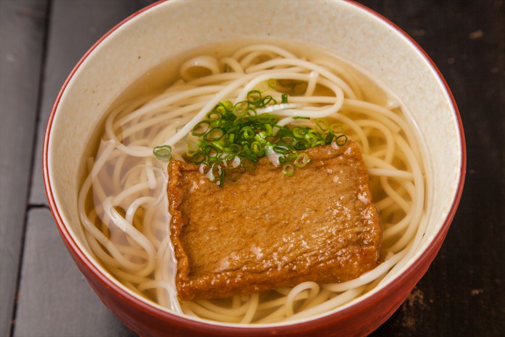 画像: <日本三大うどん「五島うどん」> 五島うどんは、島の特産である食用の椿油を塗布しながら、棒状の生地を2本の箸にかけて引き延ばしては束ねる作業を繰り返して紐状の細い麺にしていきます。この過程でしっかりと熟成を重ねたあと、乾燥させます。この伝承の技を受け継ぐ麺匠の腕によって、コシが強く、切れにくい五島うどん特有の麺へと仕上がります。 ■かけ 490円 ■ざる 490円 ■天ぷら(バラモン揚げ) 580円 ■昆布 580円 ■肉 650円ほか