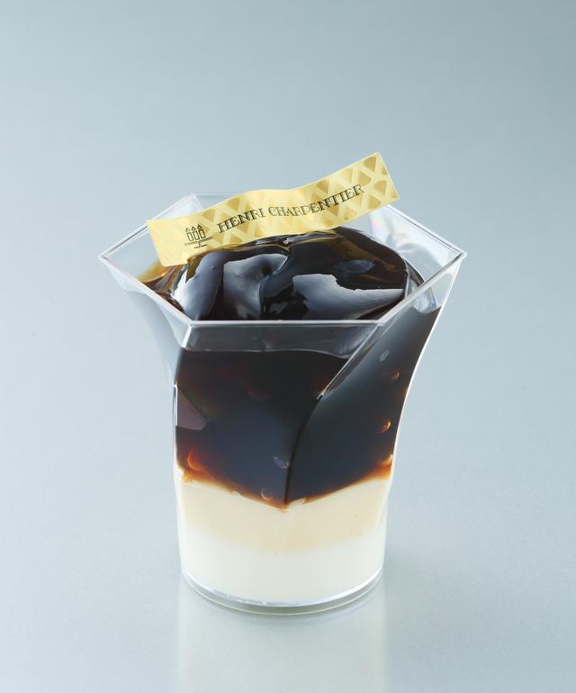 画像: 下からマスカルポーネフレッシュの白、泡クリームの薄茶色、コーヒーゼリーの濃い茶色を順に重ね、きれいなグラデーションを表現しました。コーヒーゼリー部分のエスプレッソは香りと旨みが引き立つよう、マシーンで抽出したものを使用しています。コーヒーの程よい苦みに、ほんのりラム酒を効かせたマスカルポーネフレッシュが絡む大人の味わいです。混ぜることで、コーヒーゼリーにマスカルポーネフレッシュが全体にいきわたり、より滑らかなのど越しを感じていただけます。 【販売価格】 ¥540/直径 82mm × 高さ 80mm(エスプレッソゼリー上部まで)