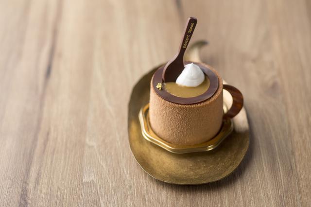 画像: ◆シナモンとバナナのコーヒーケーキ 550円 バナナクリームとシナモンクリームを閉じ込めたコーヒームースをミルクチョコレートで覆いました。チョコレートで作った持ち手とスプーンを添えて、コーヒーカップに見立てたかわいらしいデザインは、食べてしまうのがもったいないくらいの仕上がりです。