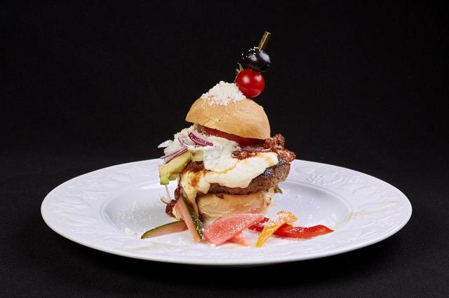 画像: 自家製フォカッチャバンズバーガーイタリアン ¥1,500 (アンディアーモ) フォカッチャで包み込むのは、自家製ボロネー ゼにモッツァレラ、牛肉 100%パテと、トレビ ス、アーリーレッド、アボカド。シーザー風味の タルタルソースが酸味をプラスし、夏野菜の彩 り鮮やかなメニューです。