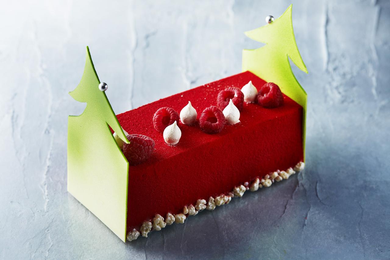 画像: 「ラズベリーとピスタチオのブッシュ ド ノエル」(L：5,200円 S：850円) 目にも鮮やかな赤と緑がムードを盛り上げる、クリスマスカラーのブッシュ ド ノエル。甘酸っぱいラズベリーのコンフィとババロア、なめらかなピスタチオのクリームとの組み合わせが絶妙なハーモニーを奏でます。口の中でパチパチと音を立てるキャンディーが遊び心をくすぐり、明るく楽しいパーティを演出します。