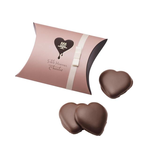 画像: 【商品名】しあわせサブレ<チョコレート> 【価格】◎3枚入り¥450/◎6枚入り¥900 定番商品のしあわせサブレをハート型の愛らしい形はそのままに、チョコレートでドレスアップしました。まろやかなミルクチョコレートと、ほんのり塩味を効かせたサブレが絶妙の味わいです。3枚入りからご用意しているので、日頃の感謝を伝えるプチギフトとしてもおすすめです。