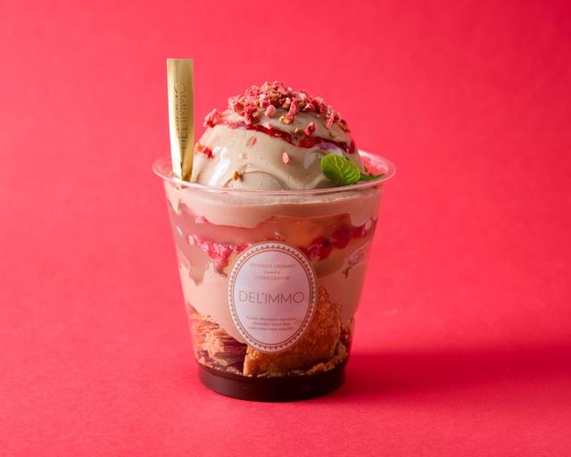 画像: 57%のビターショコラを含んだチョコレートソースとパイ生地をカップの一番下に敷き詰め、パッションシロップに漬け込んだオレンジをふんだんにトッピング。チョコレートソースをかけたブラッドオレンジのアイスとダックワーズを、ホワイトチョコレートの半球ドームで包みこみ、パッションソースを添えた味わい深い一品となっています。口の中でパチパチとはじけるキャンディーチョコレートをトッピングに加え、ブラッドオレンジのアイスが、ショコラと絶妙のハーモニーを奏でます。