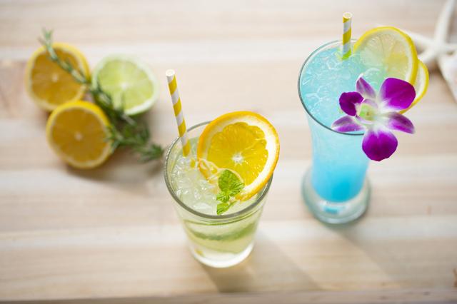 画像: ■「シトラスモヒート」:950円 (写真左) ※アルコール飲料 フレッシュなライムやオレンジなど、シトラスフルーツを贅沢に使用したすっきり爽やか系モヒートです。 ■「シトラスマリン」:950円 (写真右) ※アルコール飲料 レモンのすっきりとした甘酸っぱさとホワイトソーダのまろやかな甘さがバランス感抜群のドリンク。爽やかなブルー色とデンファレの花がフォトジェニックに映ります。
