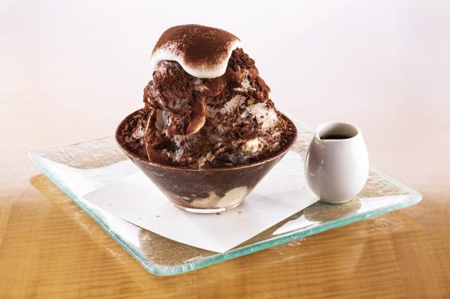 画像: イタリア生まれのデザートが“かき氷”と出会い新食感で楽しめる氷スイーツとなりました。 初めにエスプレッソコーヒーを浸み込ませたビスキュイを土台に添え、氷とのバランスを考え特別にお作りした マスカルポーネのクリームを絞ります。そこにふんわりと削ったかき氷と贅沢に振り掛けたココアパウダーを重ね、4層にし、最後に柔らかくホイップした生クリームを全体にかけて仕上げていきます。エスプレッソのソースは別添えでご用意いたしますので、苦味の調節はお客さまのお好みに合わせて様々なテイストをお試しいただきながらお召し上がりいただけます。