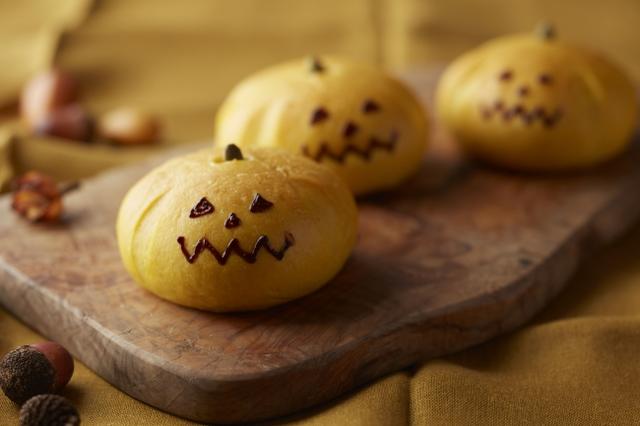 画像: ◆ かぼちゃあんぱん 9月より販売を開始するかぼちゃあんぱんを、期間限定でハロウィン風に仕上げたスペシャルバージョンです。かぼちゃペーストを練り込んだ生地でブランデーが香るかぼちゃ餡を包みました。ジャック・オー・ランタンの顔も描いた見た目もかわいらしいあんぱんはおやつ感覚でお召し上がりいただけます。 料金:¥223 (税金別)