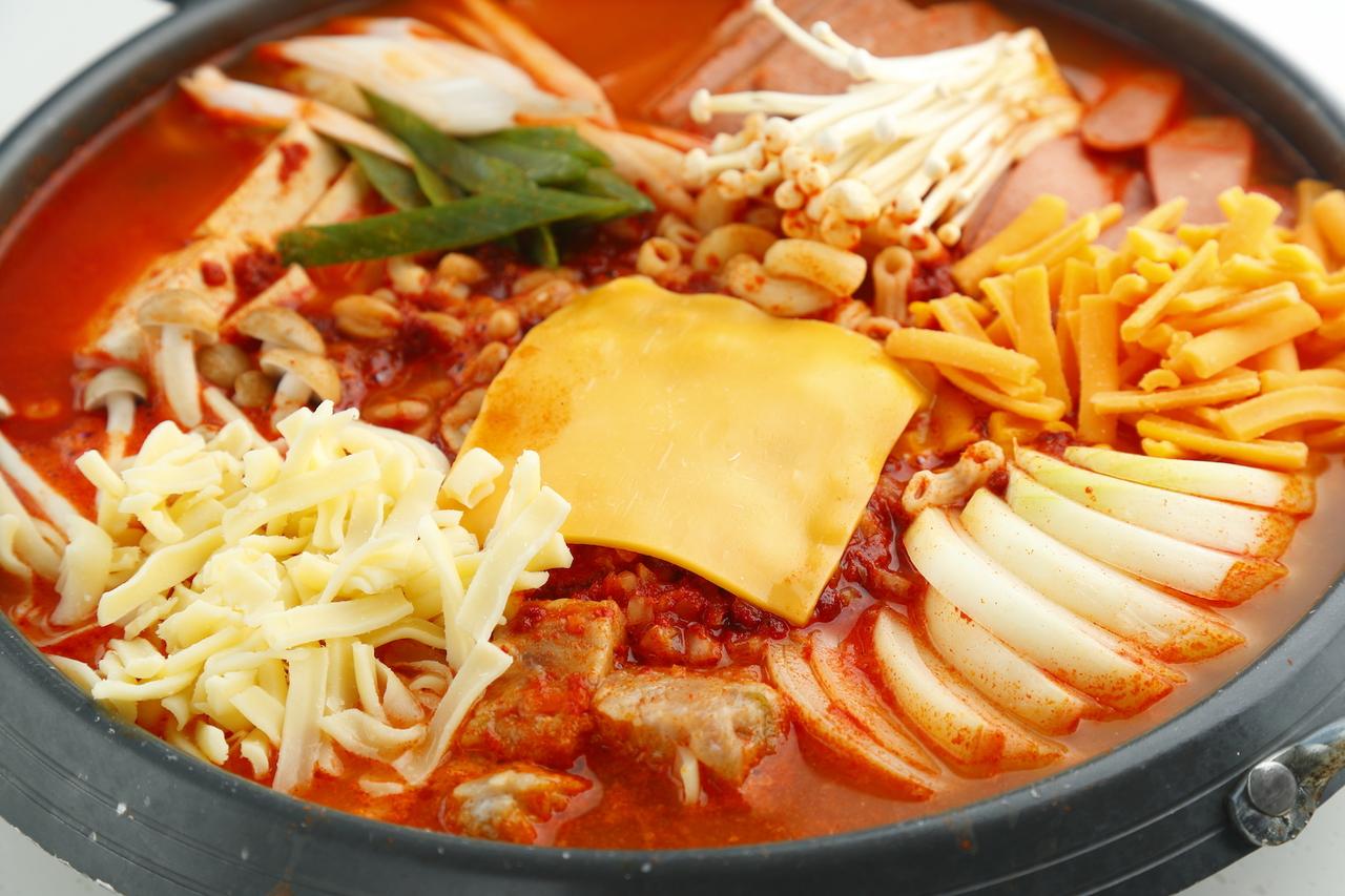 画像: ・チーズプデチゲ ソーセージ、ハム、各種野菜、仕上げにとろ~りチーズをたっぷりのせてマイルドに仕上がった一品。プデチゲ+チェダーチーズ×モッツァレラチーズ=最高の組み合わせです。 価格:3,280円(税別) (2~3人分)