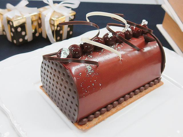 画像: 【ビュッシュ・ショコラ・ヴァニーユ】 大人向けの本格的なチョコレートクリスマスケーキです。ふわりとした軽やかなムースとクリームの中にキルシュ漬けした甘酸っぱいグリオットチェリーとソテーした洋梨が入っています。