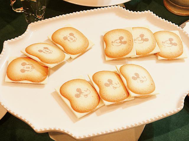 画像: ミッキーがプリントされたラングドシャクッキーに、はみだしサイズのショコラをサンドしました。ショコラはバナナミルクシェイク味です。あまいバナナの香りがします。東京土産としてオフィスでも配りやすい個装タイプです。 © Disney