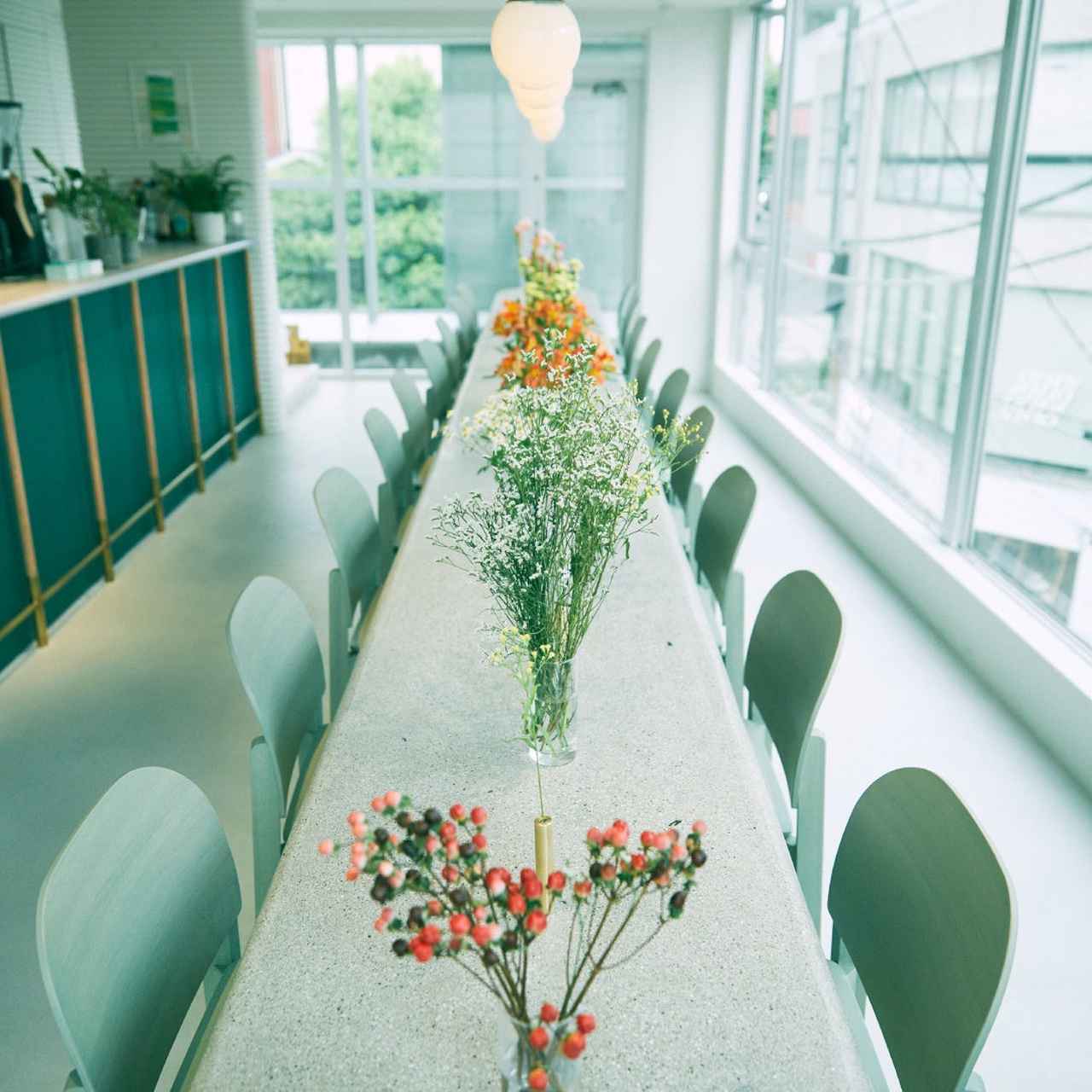 画像: 深緑・白を基調とし、花で彩る店内