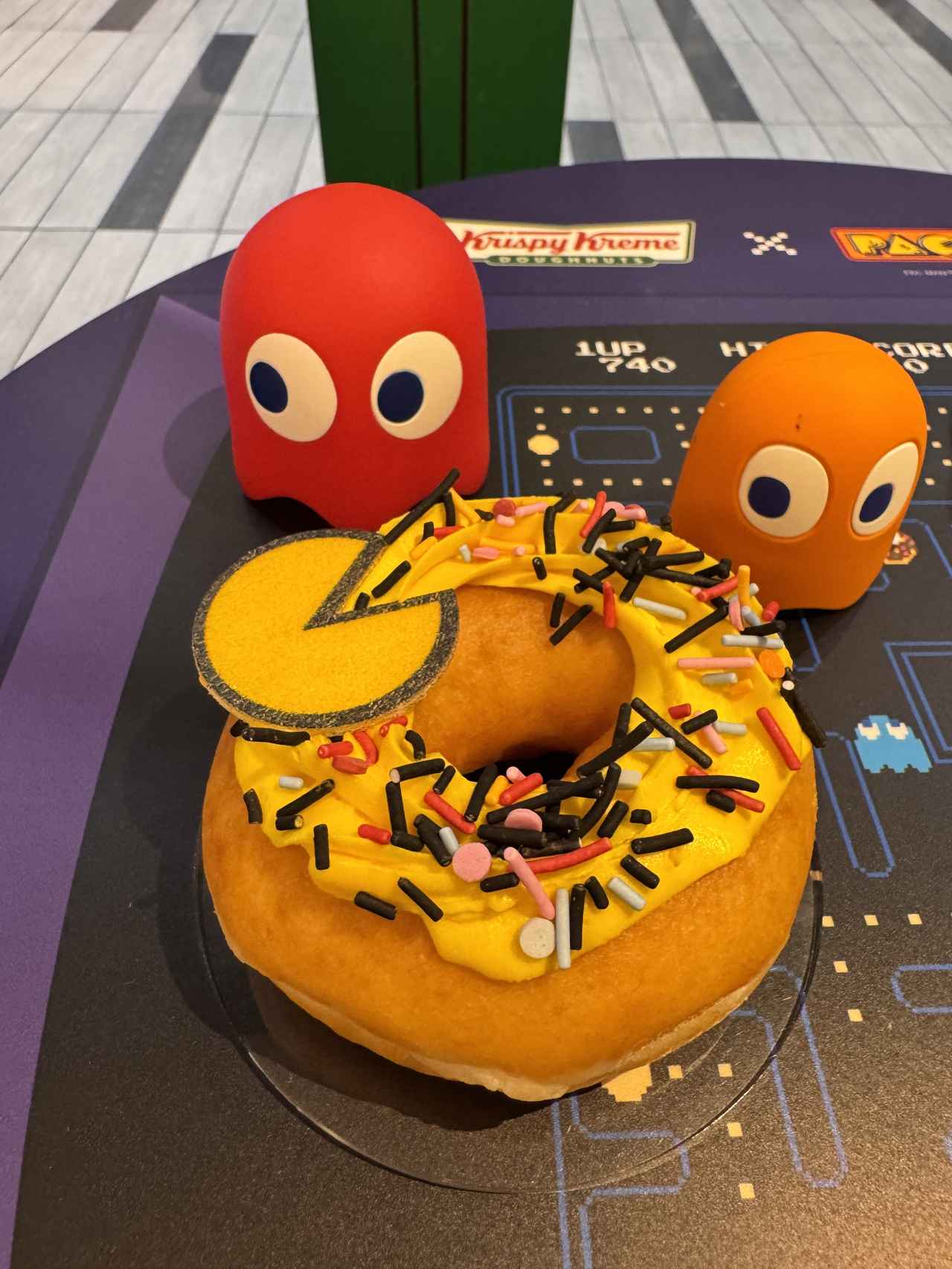 画像: 『パックマン カスタード スプリンクル 』 【販売期間】2025年5月14日（水）～6月中旬頃 【販売価格】410円（イートイン418円） 見ても食べても楽しい遊び心あふれる「パックマン」45周年コラボドーナツ。 リングドーナツにほんのりカスタード風味のクリームを搾り、ゴーストたちのカラーをイメージしたスプリンクルをトッピング。 モナカのパックマンものせました。