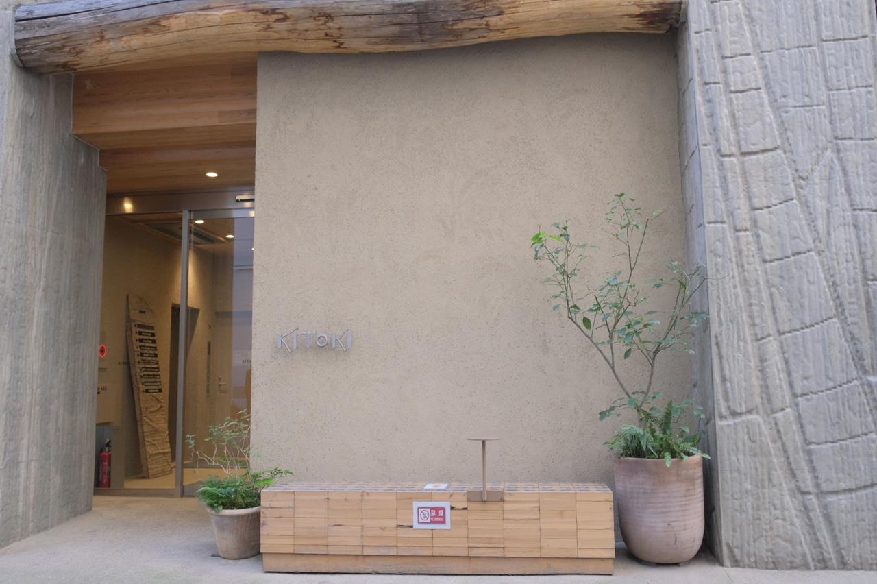 画像: kitoki 日本初の木造ハイブリットビル。無機質なイメージの強い都心の金融街だからこそ、木材を多用した自然を感じられるデザインによって温かみのある空間に。ビルの外観を印象付ける4本の柱には、デザインデータとNC加工機を連動し製作した木製型枠にコンクリートを打設・転写させることで、それぞれ1本ずつカブトムシ・トンボ・テントウムシ・バッタの4種類の昆虫の羽のデザインが施されています。