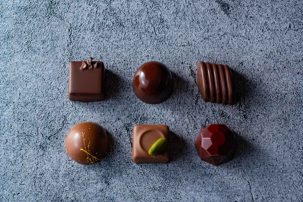 画像: 新作「ショコラティエ スペシャル2026」  4個入：1,800円（税込） ハイカカオ/ラムレーズン＊/ピスタチオ/グロゼイユ＊（アルコール入2種、ノンアルコール２種） ＊アルコール使用 6個入：2,600円（税込） ハイカカオ/ラムレーズン＊/マカダミアナッツ/ハニージンジャー/ピスタチオ/グロゼイユ＊ （アルコール入2種、ノンアルコール4種）＊アルコール使用