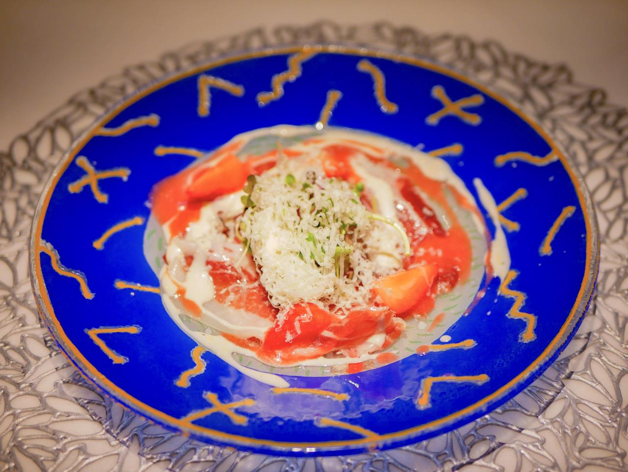 画像: 1皿目：スペイン産生ハムといちごのシーザーソースサラダ。熟成チーズを削りたてで