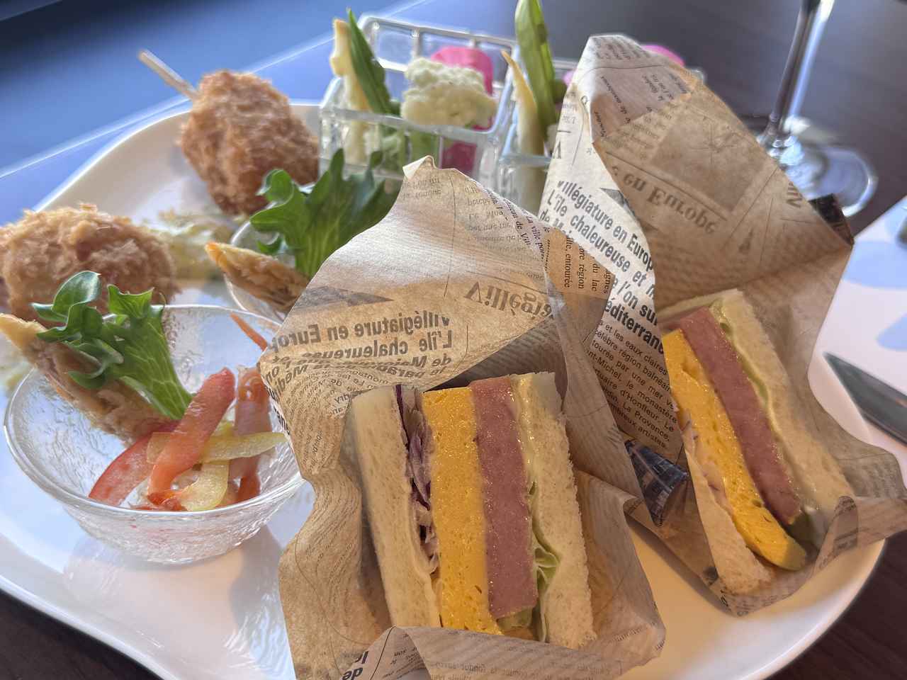 画像: ・彩り野菜とフムスのディップ ・芝海老のエスカベッシュ ・マグロのメンチカツ、バジルのタルタルソース ・スパムと玉子焼きのサンドイッチ