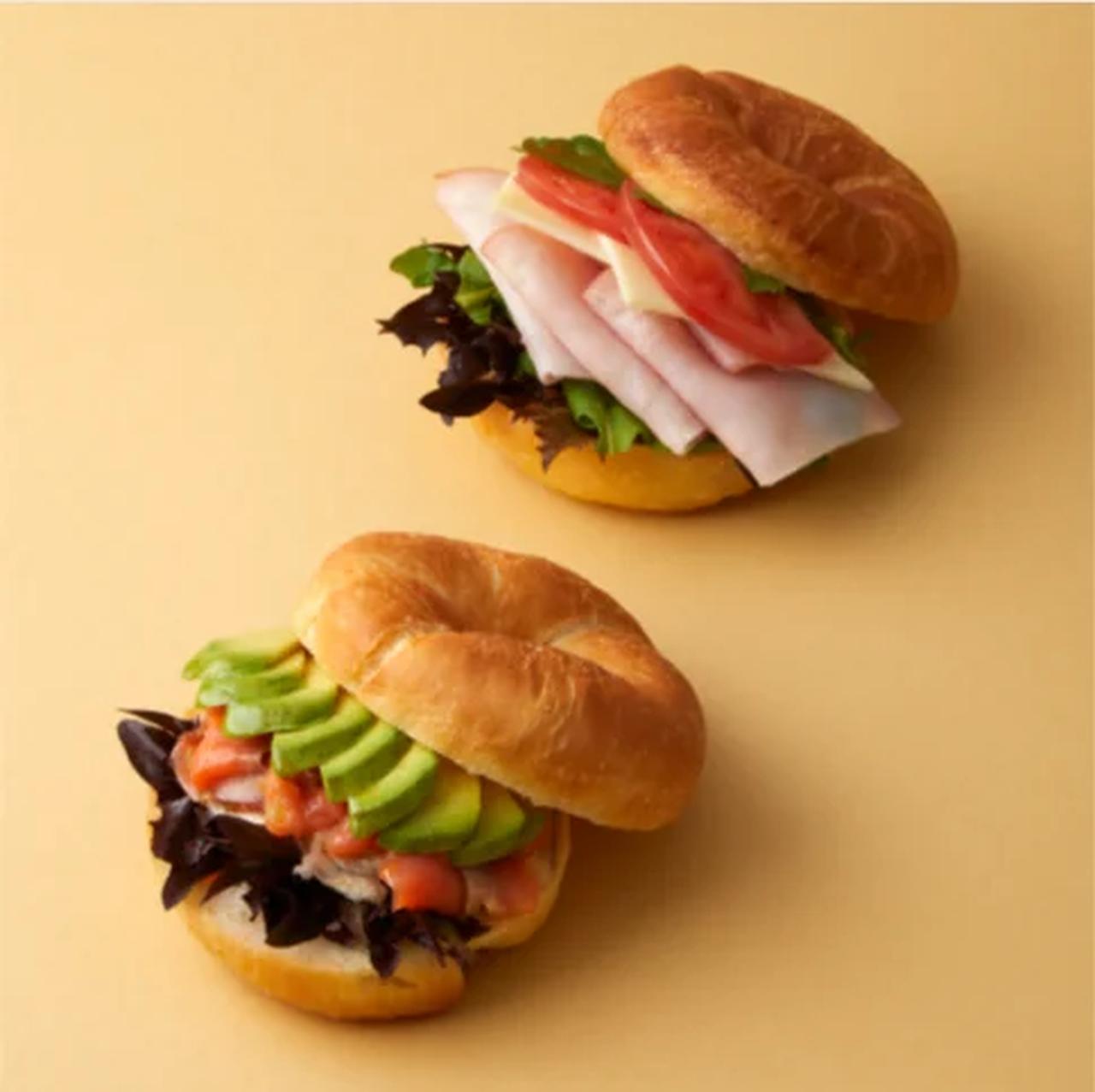 画像: 溺れバターの塩パンサンド 2種 グリエール&ロースハム: コク深いグリエールチーズとロースハムの王道コンビ。ルッコラやトマトの瑞々しさに、フレンチマスタードの辛みで味に奥行きを出した、シンプルながら質の高い組み合わせです。 サーモン&アボカド: スモークサーモンとアボカドの贅沢な組み合わせ。クルミの食感が楽しいハニークリームチーズを合わせ、塩味と甘みの絶妙なバランスを表現。ディルレリッシュの爽やかな香りがアクセントです。 販売期間: 8月20日(木)~9月2日(水)予定 価格: 各1,080円(税込)