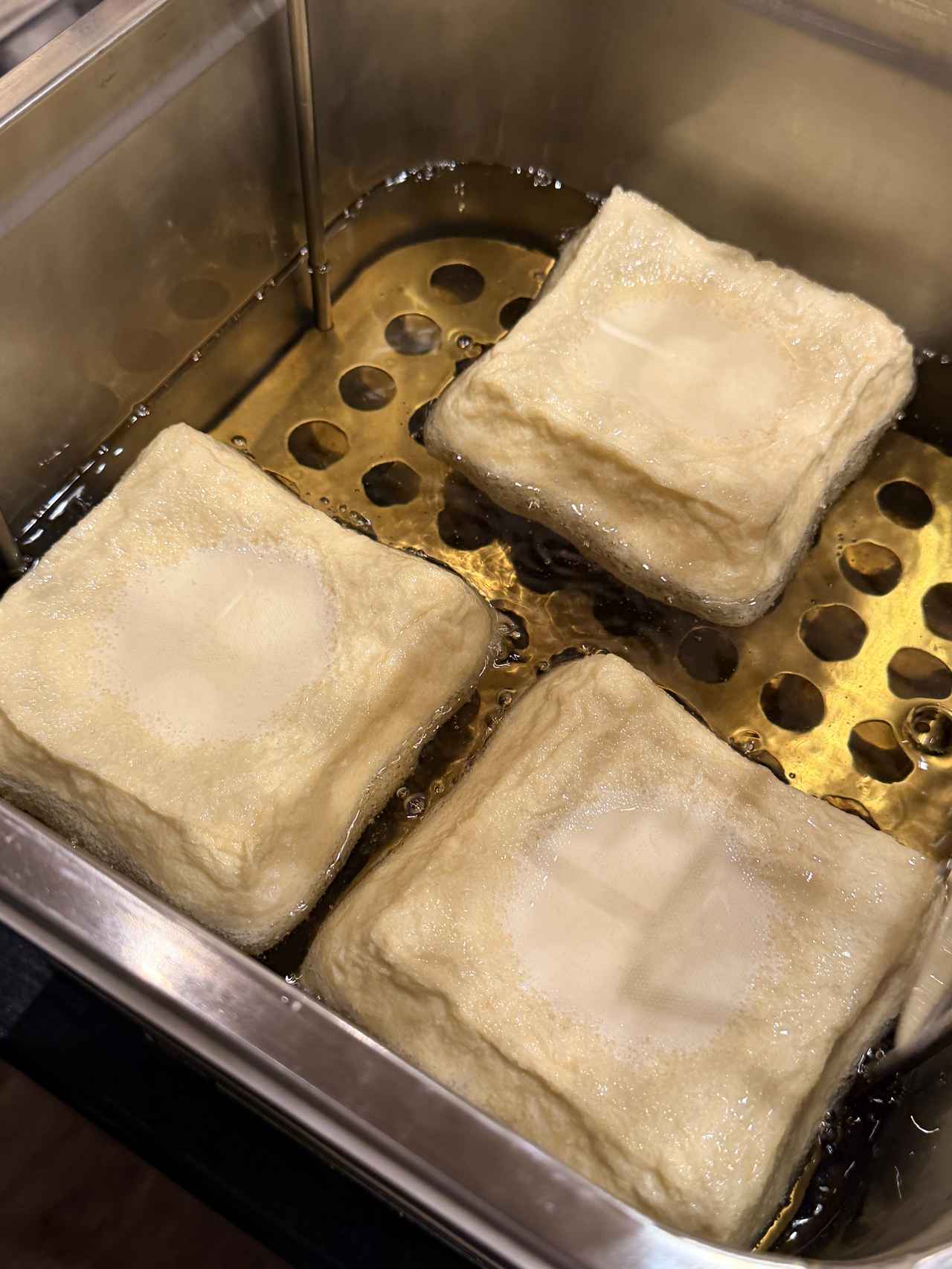 画像: 通常1時間かけてゆっくり揚げるところ、15分で仕上げることで半生に。温度の上げ下げを繰り返し最後に高温で外側をカリっと仕上げます。