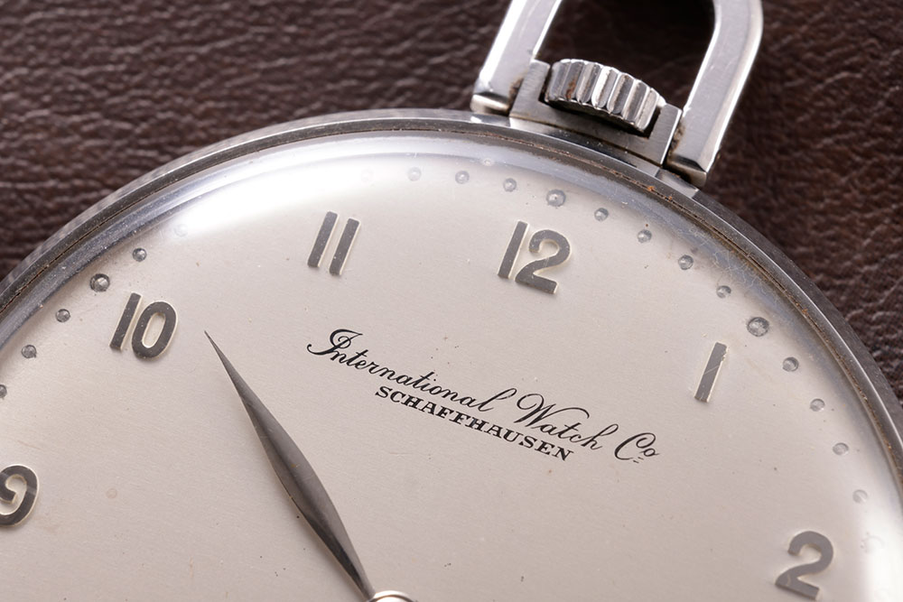 画像: 文字盤12時位置に配された旧ロゴ。筆記体の「International Watch Co.」が、当時のIWCらしい優雅さを物語る
