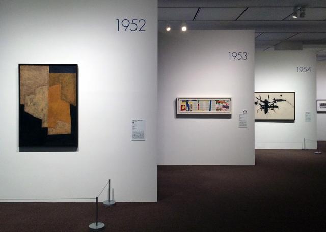 画像: ホワイトの壁。1年1作家1作品ずつ一つの壁面に展示されています。 作品の壁面の間にブルーの作家プロフィールの壁面が並びます。 photo©cinefil