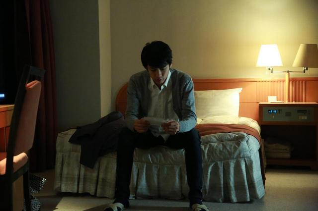 画像: ホテルで写真を見つめる樹(馬場良馬) (c)『一人の息子』製作委員会