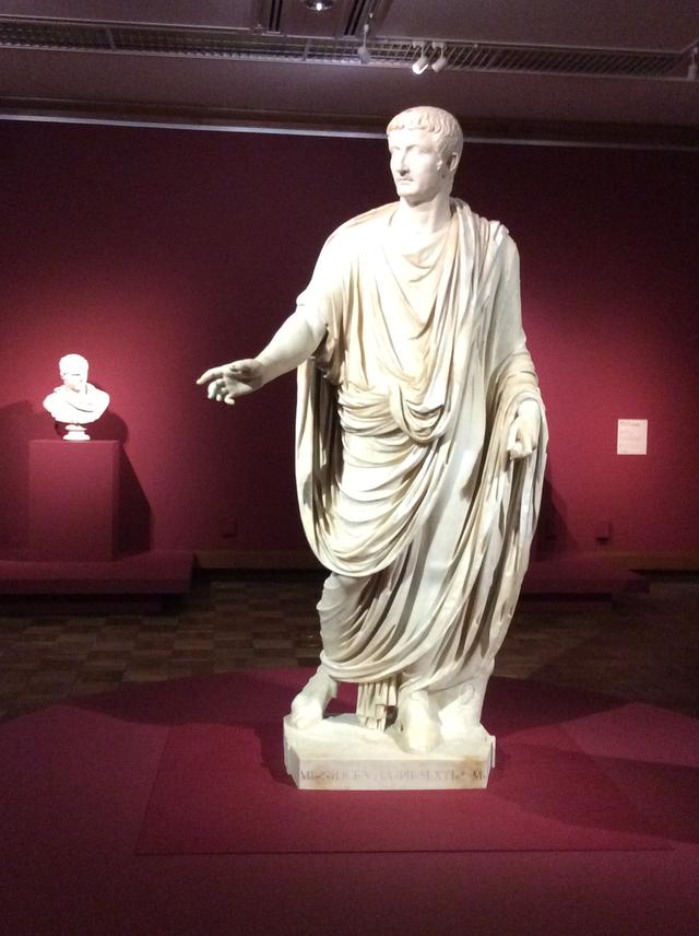 画像: 手前:《トガをまとったティベリウス帝の彫像》 イタリア、カプリで発見(身体のみ) 40年ごろ(頭部); 50−60年(身体) 大理石 高さ 230cm 奥:《胴鎧をまとったカラカラ帝の胸像》 イタリア、ティヴォリで1769年(?)に発見 212−217年(頭部) 大理石 高さ 66cm photo©︎cinefil