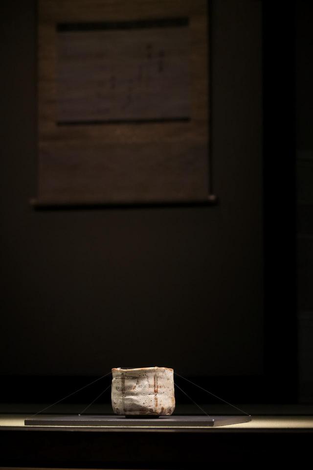 画像: 志野茶碗 銘「卯花墻」 安土桃山時代 16〜17世紀 旧・江戸冬木家伝来 明治20年代半ばより室町三井家に 今年は茶室「如庵」(織田有楽斎 作)の再現コーナーに展示。「如庵」は有楽斎が隠居先だった京都・建仁寺の塔頭、正伝院に建てたものだが、明治維新で正伝院が廃寺となり、後に三井家に買い取られて東京、続いて大磯に移築された。戦後の財閥解体で名古屋鉄道の所有になり、現在は犬山市の名鉄犬山ホテルに。国宝。 背後の軸は、後水尾上皇宸翰の和歌懐紙「深山鹿」 江戸時代18世紀 個人旧蔵