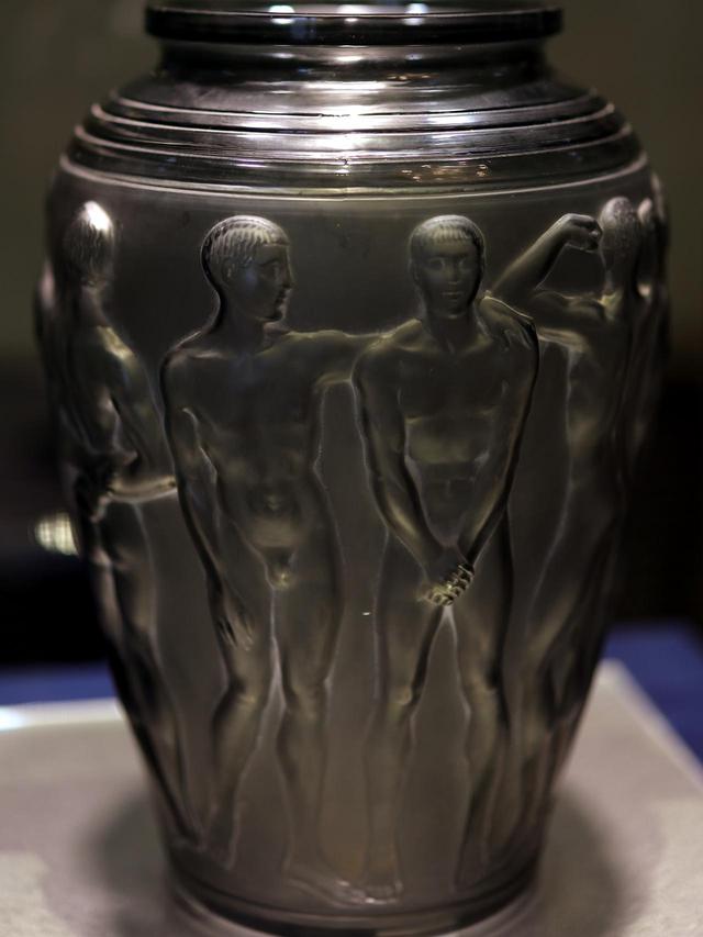 画像: ルネ・ラリック 花瓶「パレストル」1928年 メタリックな質感に見えるが、金型の中にガラスを吹いて成形した濃いグレーのスモーク・ガラスにサティネ加工を施したもの。さらに白系の顔料のパティネで輪郭線と凹凸を強調して立体感を浮き立たせている。北澤美術館蔵