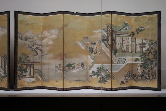画像: 狩野探幽 「両帝図屏風」江戸時代 寛文元(1661)年 右隻 主役の黄帝の宮廷は右端1/3に、やや遠ざかった中景に描かれ近景には岩と樹木が。あわせて黄帝が発明して民衆を助けたとされる車と舟がさりげなく描き込まれているが、絵の中心となるのはその舟の浮かぶ池と彼方に連なる山河