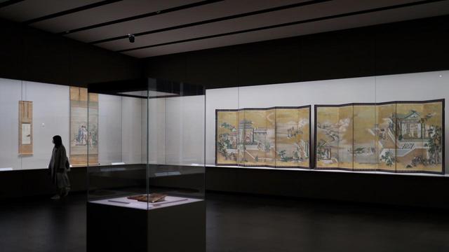 画像: 狩野探幽 「両帝図屏風」江戸時代寛文元(1661)年 探幽の息子・益信の 「玄宗皇帝並笛図」江戸時代17世紀 共に根津美術館蔵 手前には狩野惟信が下絵を描いた蒔絵の硯箱も置かれ、幕府御用絵師一門としての狩野派の活躍が凝縮された展示スペース
