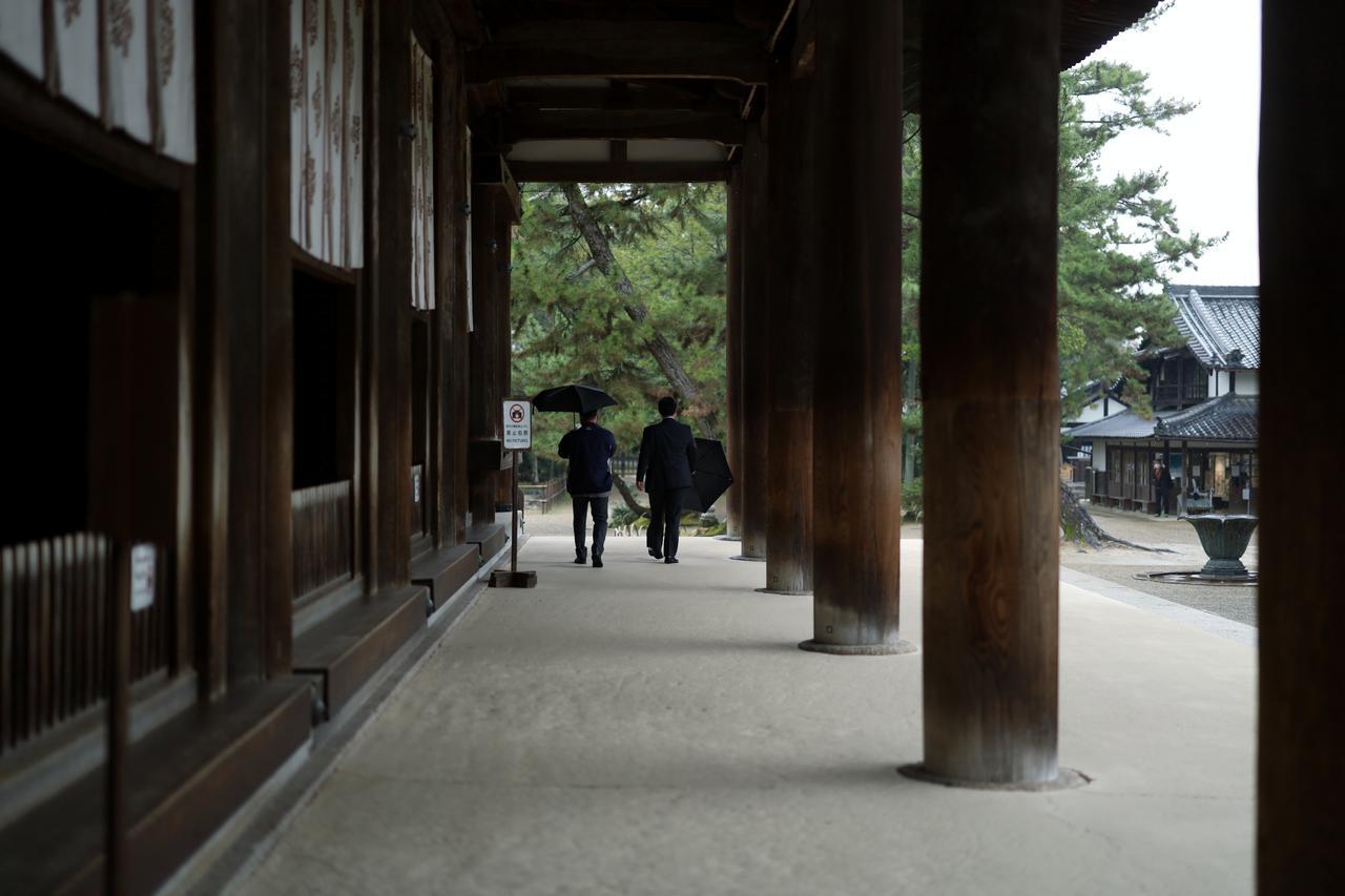 画像: 写真左の内開きの扉の向こうに三体の本尊を中心とする仏の世界が広がり、柱や天井には極彩色の宝相華や菩薩、天神天女の姿が描かれている。