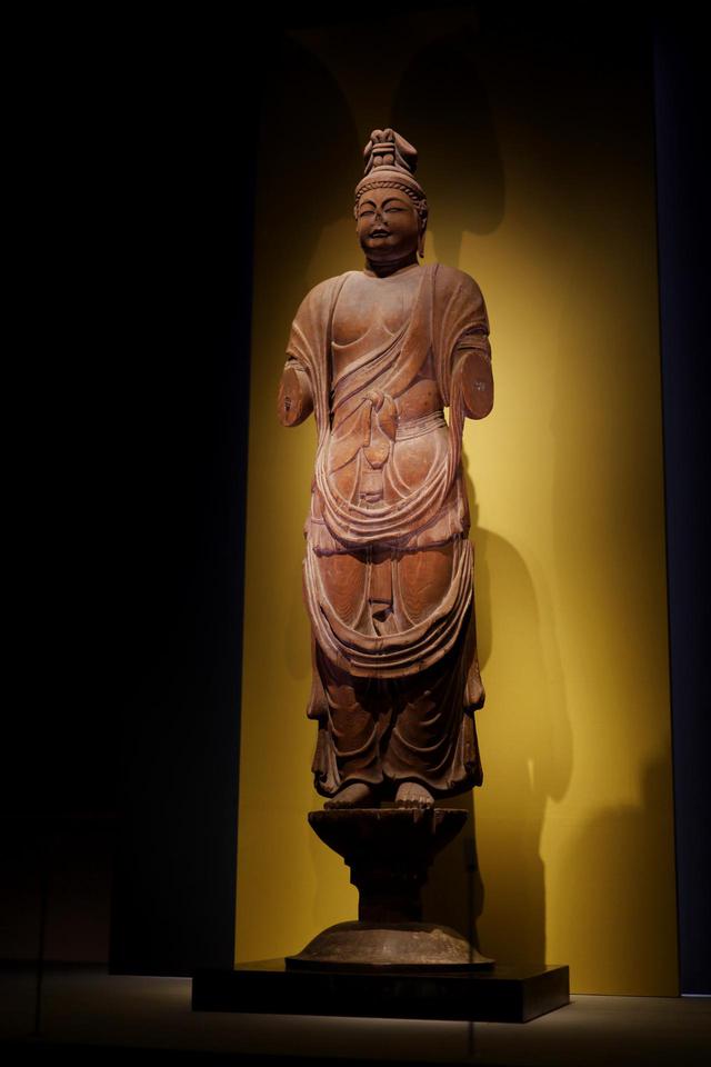 画像: 伝獅子吼菩薩立像 奈良時代8世紀 奈良・唐招提寺 国宝 失われてしまった腕以外は、頭頂から台座の蓮の芯の部分まですべてを一本の堅いカヤ材から彫り出した一木造りで、均整の取れた七頭身のふくよかな体躯、エキゾチック(インド風?)の顔、シャープな木彫技術の精度の高さから、鑑真が日本に伴った唐の仏師の作ではないかという説がある。こうした一木造りの仏像はその後平安時代前期の仏像の標準になるが、だとしたら鑑真が日本の仏教文化に与えた大きな影響のひとつとも考えられる。 獅子吼菩薩と伝わっているが、額の中央に第三の目が彫られていることや、腕の数、衣の一部に鹿革が表現されていることなどから、本来は不空羂索観音菩薩だったと考えられる。