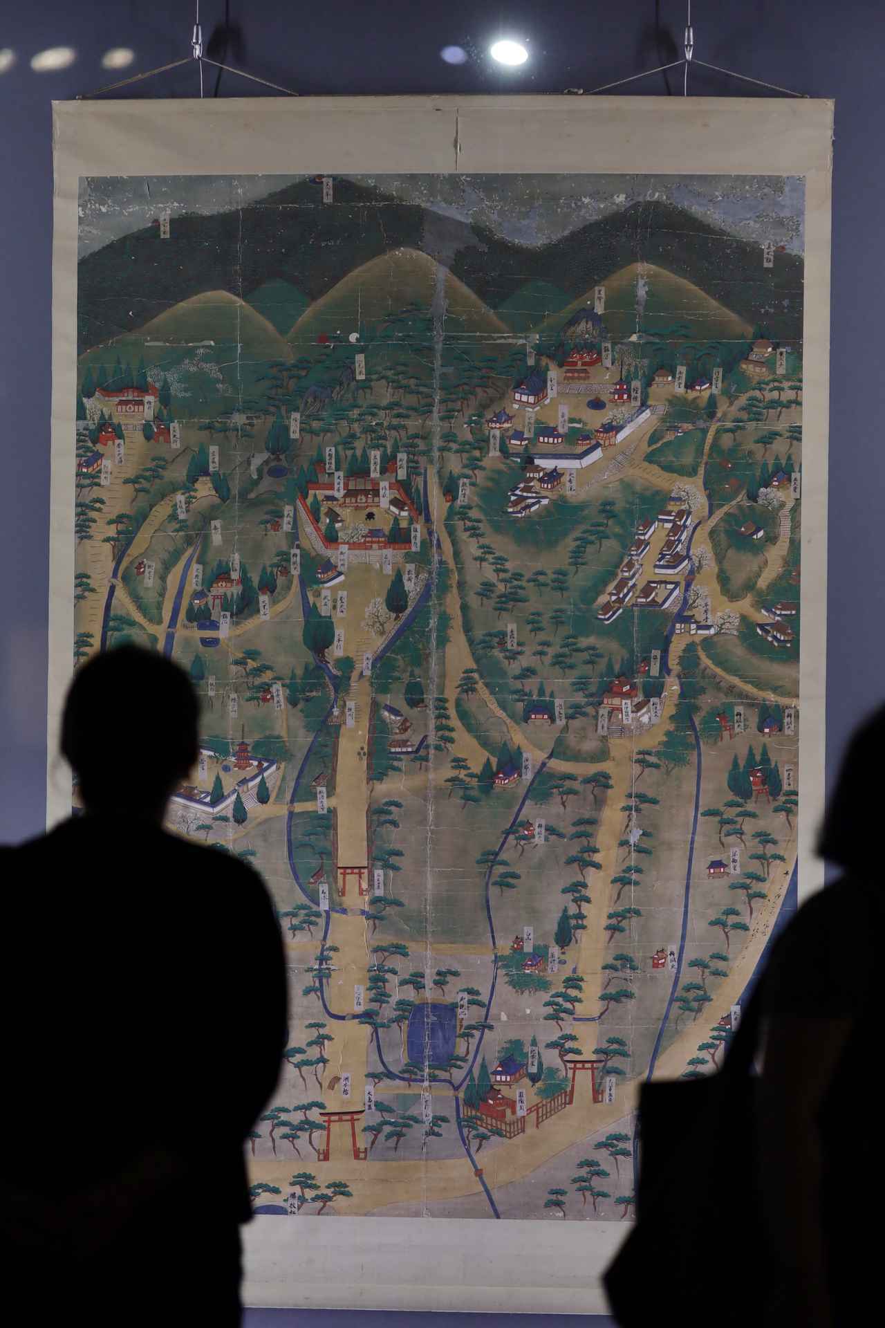 画像: 三輪山絵図 室町時代・16世紀 奈良・大神神社蔵 下から伸びる山道の先の、石垣と赤い塀に囲まれている空間が中心の社殿。その上端に拝殿と、その向こうの「三鳥居」が描かれ、その一直線上の最上部に三輪山の山頂。