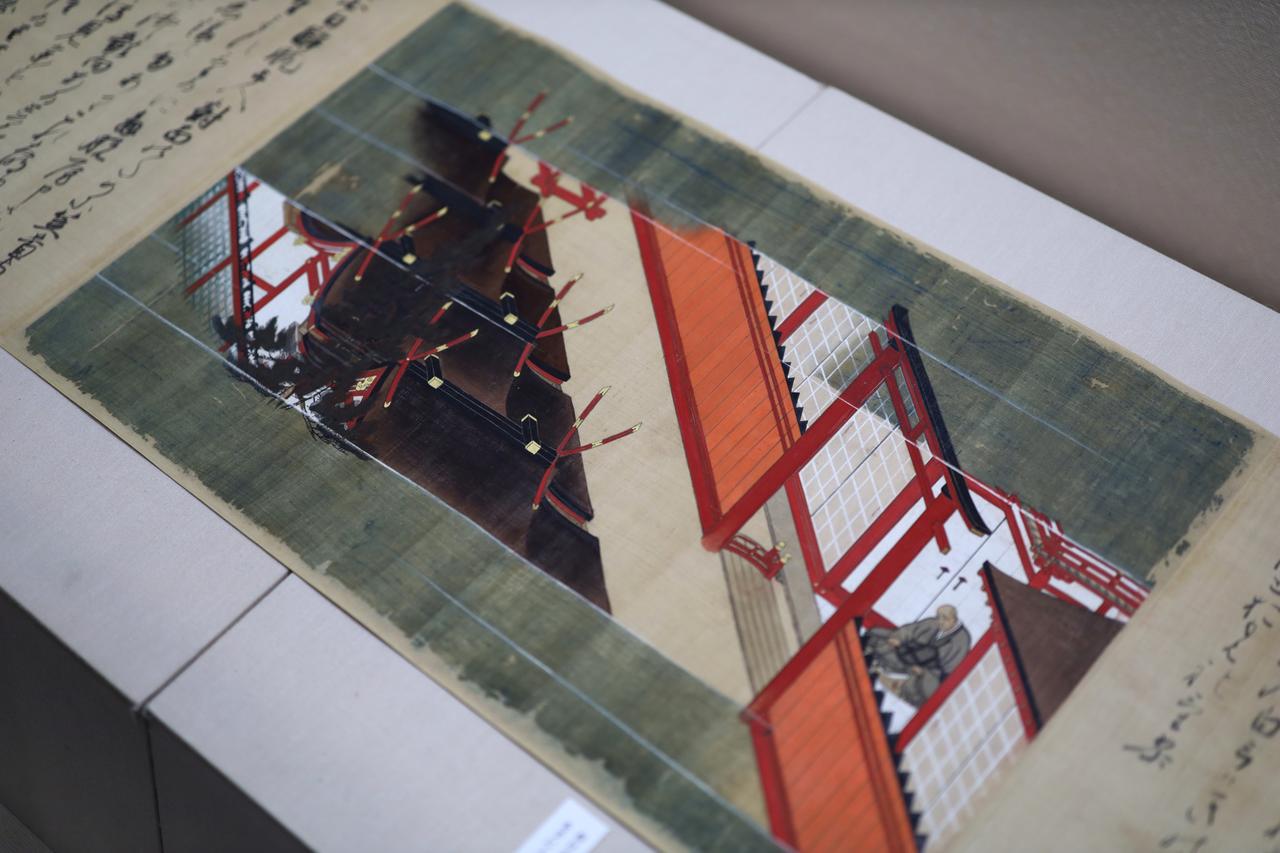 画像: 国宝 春日権現記絵 巻十八 鎌倉時代・14世紀 国（三の丸尚蔵館収蔵）展示期間：4月19日～5月18日 春日明神の使いに誘われて春日大社を詣で、本殿の前に柵を隔てて籠っている僧侶は、「鳥獣戯画」でも知られる高山寺を開いた明恵上人。神仏を崇敬し仏の分身でもある神々に祈るのは、かつての日本では当たり前のことだった。絵は朝廷に仕えた絵師・高階隆兼の手になり、紙ではなく絹本に高価な顔料をふんだんに使った濃彩で描かれた豪華本