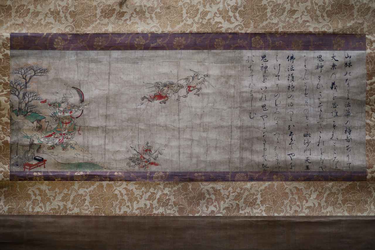 画像: 国宝 辟邪絵 全五幅のうち「毘沙門天」 平安時代・12世紀 奈良国立博物館 展示期間：4月19日～5月18日 疫病をもたらすと信じられた悪鬼を懲らしめ退治する様子を描いた元は絵巻物の一部。この図では画面左下の写経する僧侶の祈りで毘沙門天が現れ、弓矢で悪鬼を退治している。