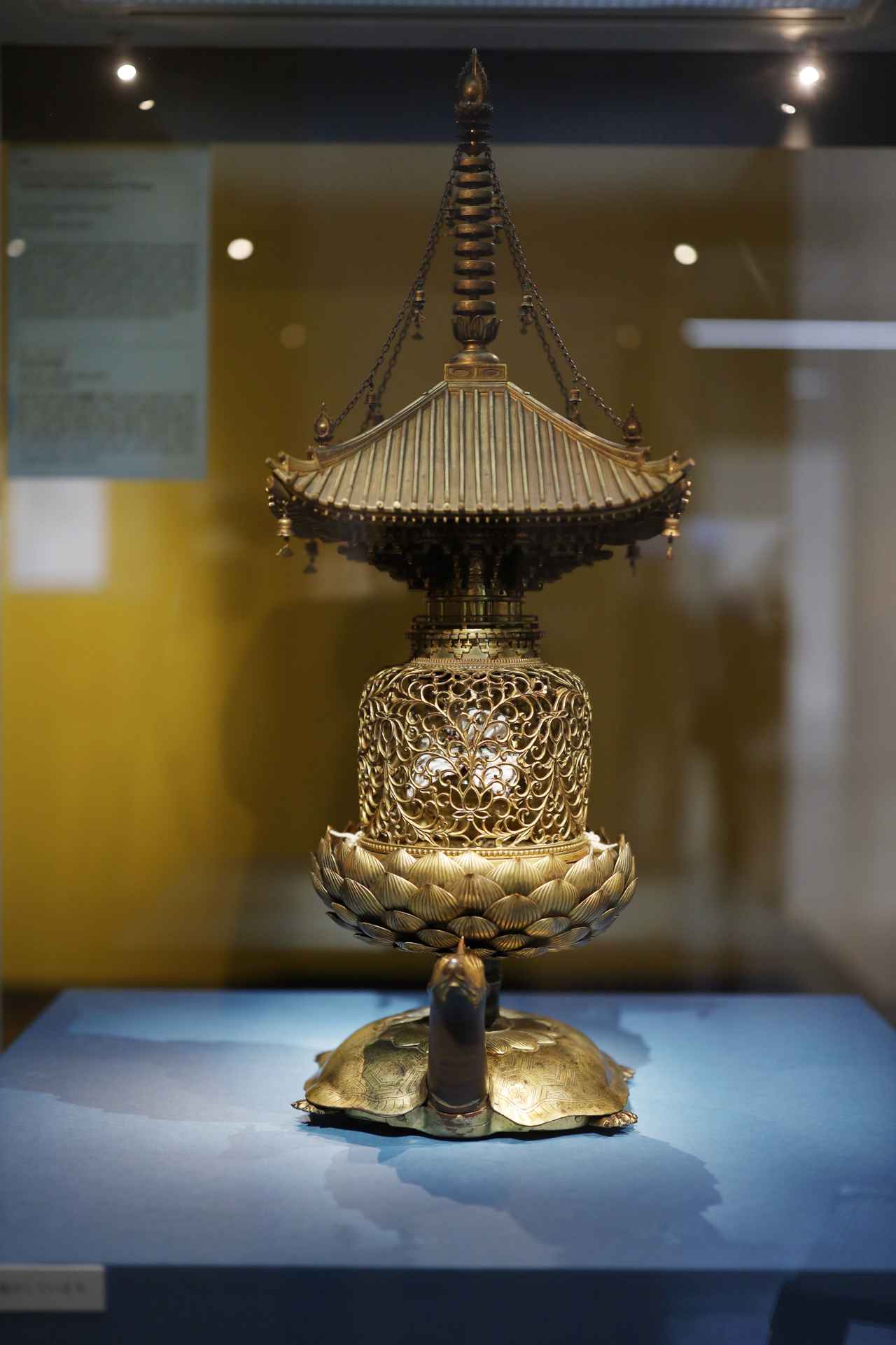 画像: 国宝 金亀舎利塔 鎌倉時代・13世紀 奈良・唐招提寺 鑑真が唐からもたらした「如来舎利三千粒」を収める白瑠璃（ガラス）の器を内部に収納するために、鎌倉時代の唐招提寺復興時に造られた金属工芸の粋。鑑真が渡航を試みた船が難破した際、海に沈んだ舎利を亀が背に載せて浮かび上がってきた、との伝承にちなんで台の部分が亀のデザインで、中央の金の打ち物の透かし彫りの中に白瑠璃の舎利容器が納められる。