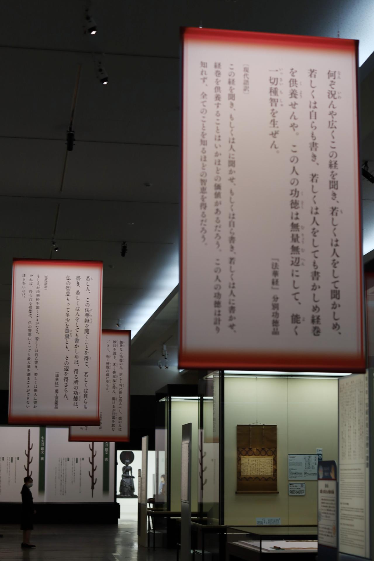画像: 展示の後半最終盤、中宮寺の菩薩半跏像に至る順路に掲げられた、『法華経』と『弥勒大成仏経』の抜粋