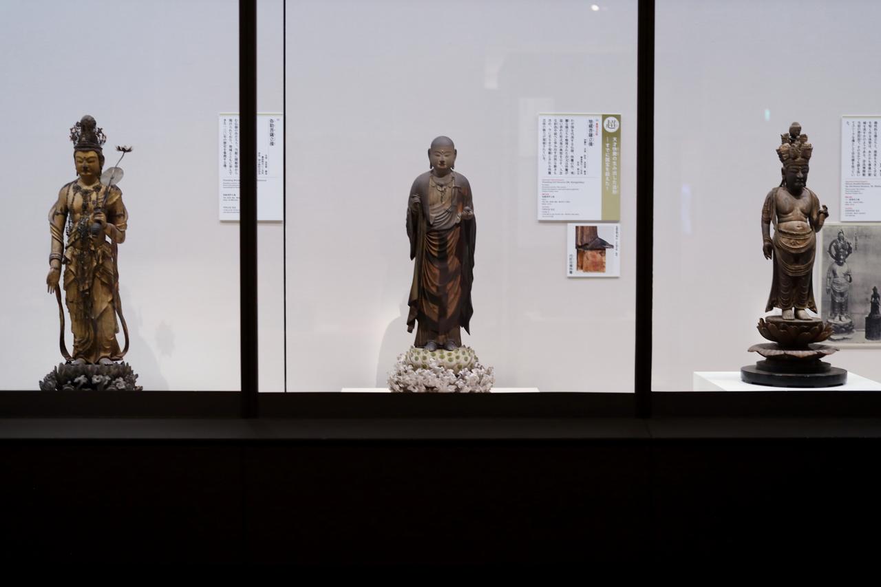画像: 展示風景。かつて、あるいは今も奈良博に寄託されて保護された三体の仏像。左から弥勒菩薩立像（奈良市林小路町自治会）、快慶作・地蔵菩薩立像（東大寺、重要文化財）、十一面観音立像（霊山寺、重要文化財）